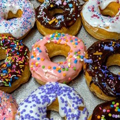 A group of donuts with sprinkles

Description automatically generated