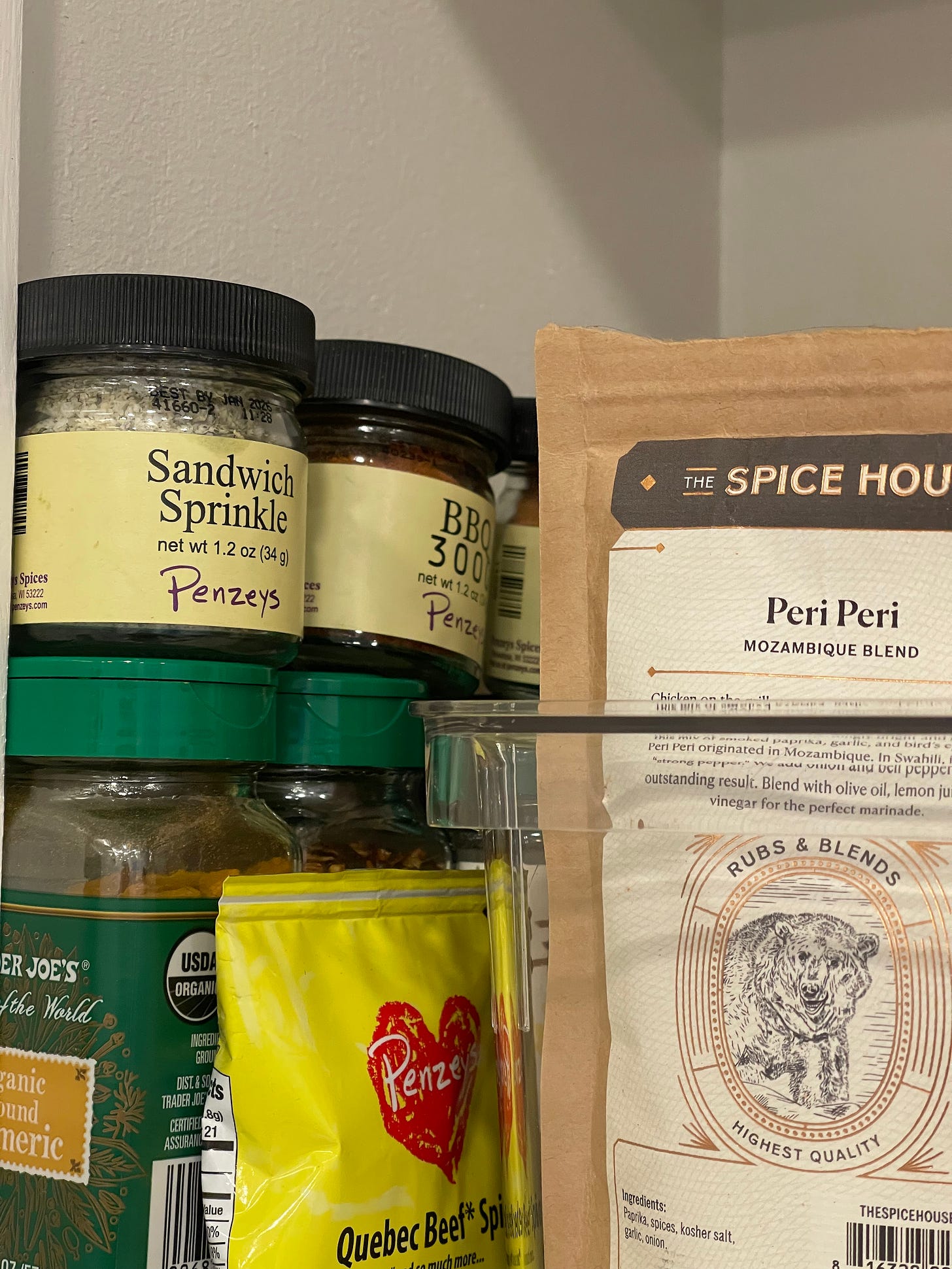 Spice cabinet featuring Peri Peri spice pack mix, Sanwich Sprinkle in a jar, and other jarred spices