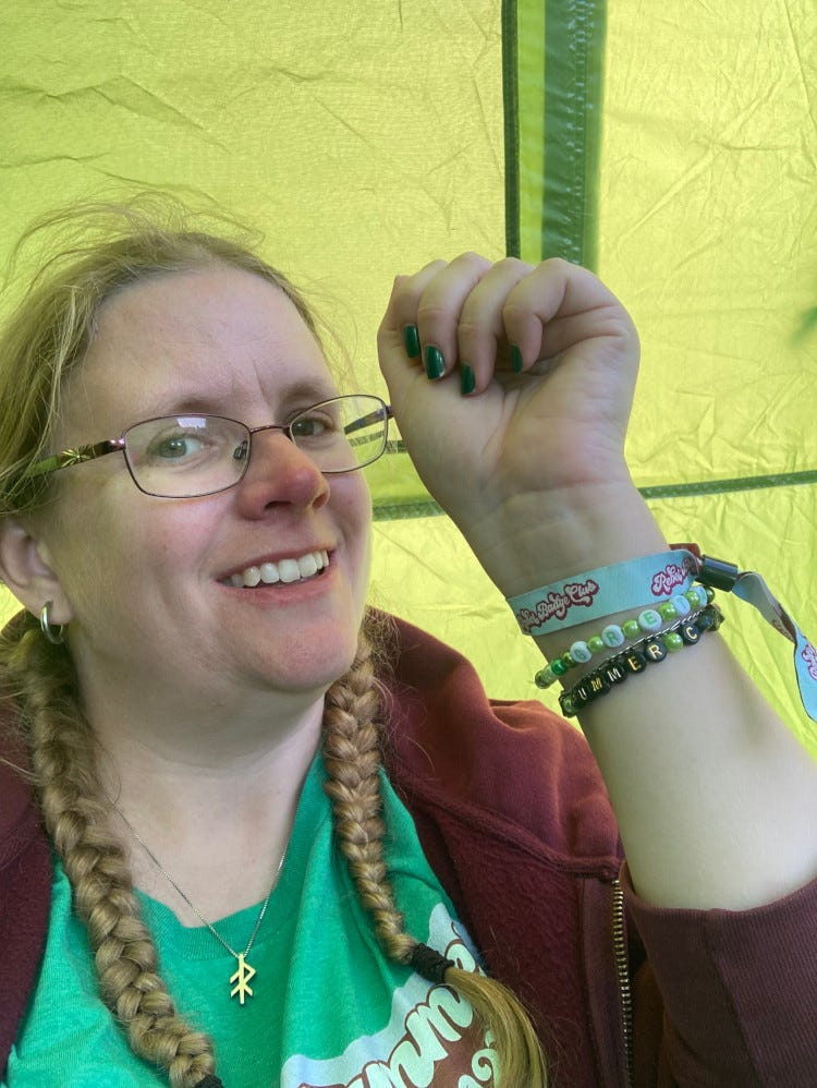 Selfie sitting inside my green tent wearing my green Greta patrol t-shirt, green nails, a green beaded Greta Patrol friendship bracelet and a Rebel Summer Camp friendship bracelet with black letter beads, plus my light blue Rebel Summer Camp wristband.