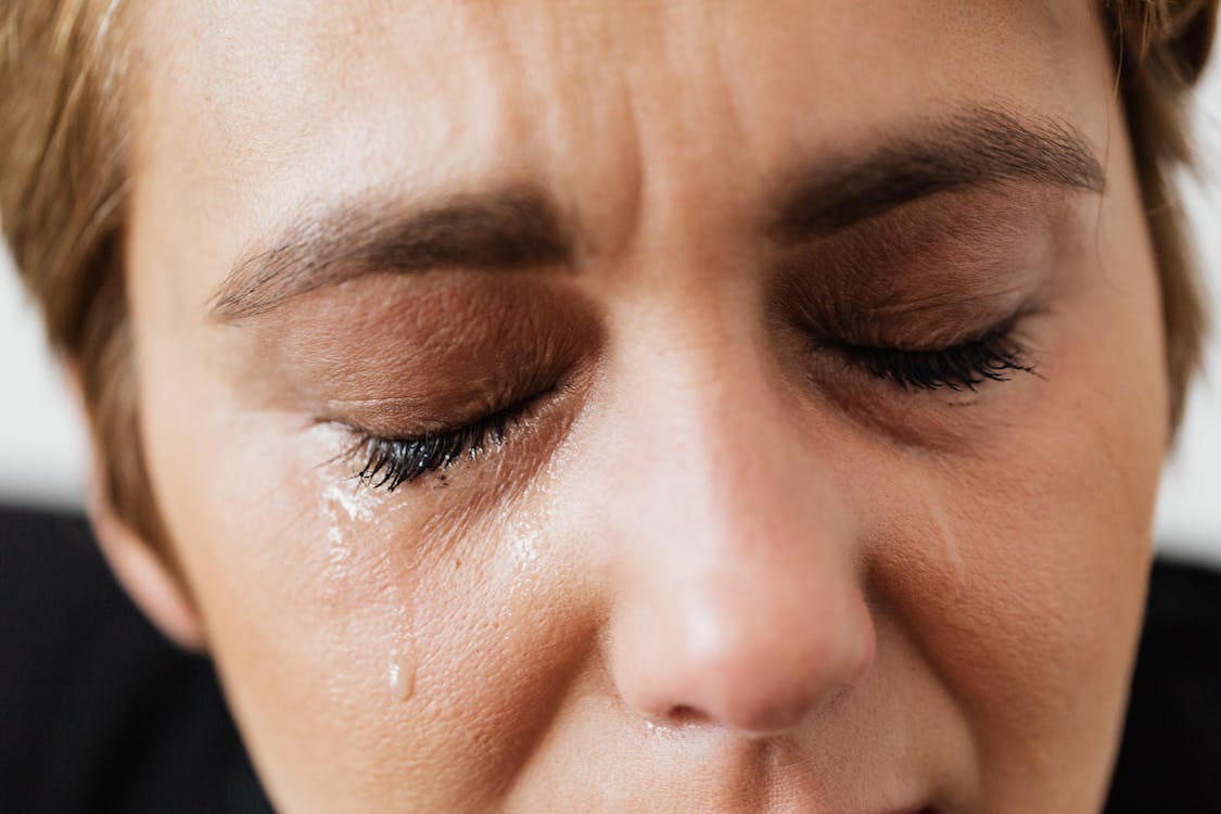 Free Tears on face of crop anonymous woman Stock Photo