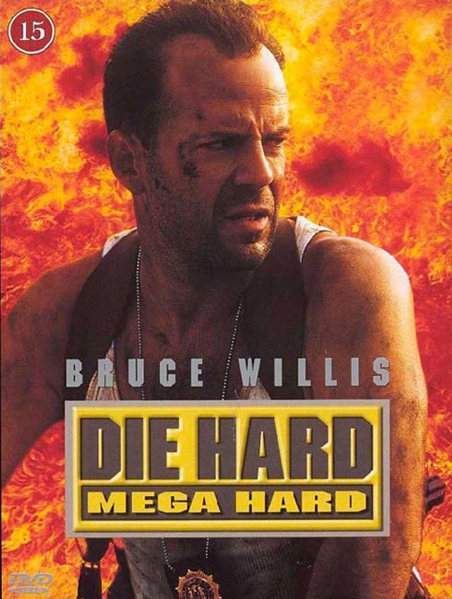 Cover of the German DVD of Die Hard With a Vengeance, using the localized title Die Hard Mega Hard. Bruce Willis in a sleeveless shirt and bruises looking off camera in front of a wall of flames.