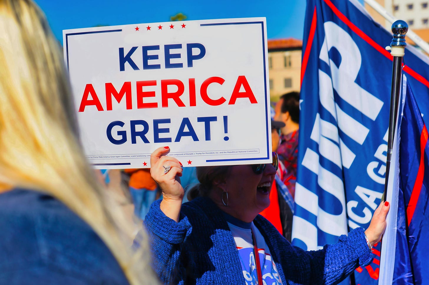 A Trumper holding up a few pro-trump flags. 