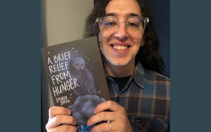A man with long hair, smiling, holds up a book titled "A brief relief from hunger"