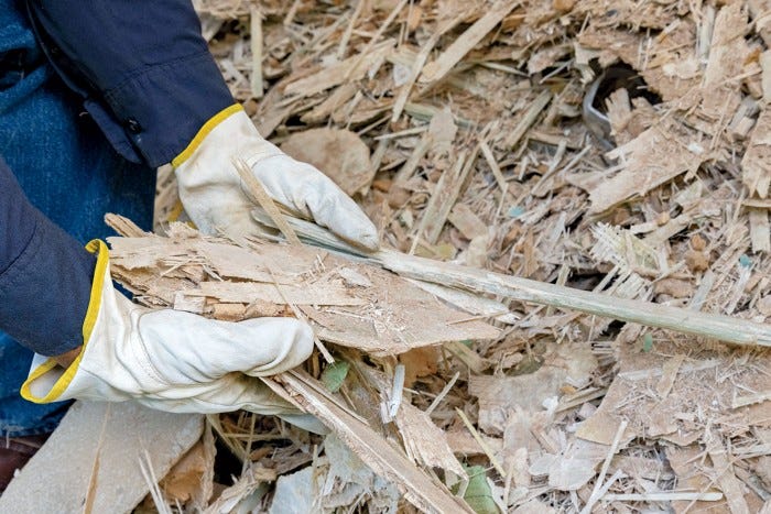 A worker’s hands holding shredded blade material.