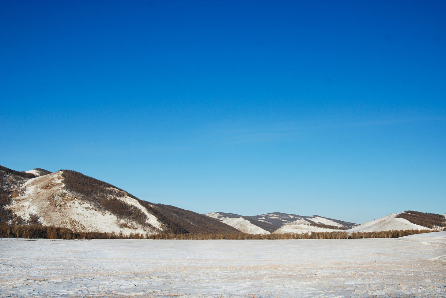 steppa innevata con basse colline sullo sfondo