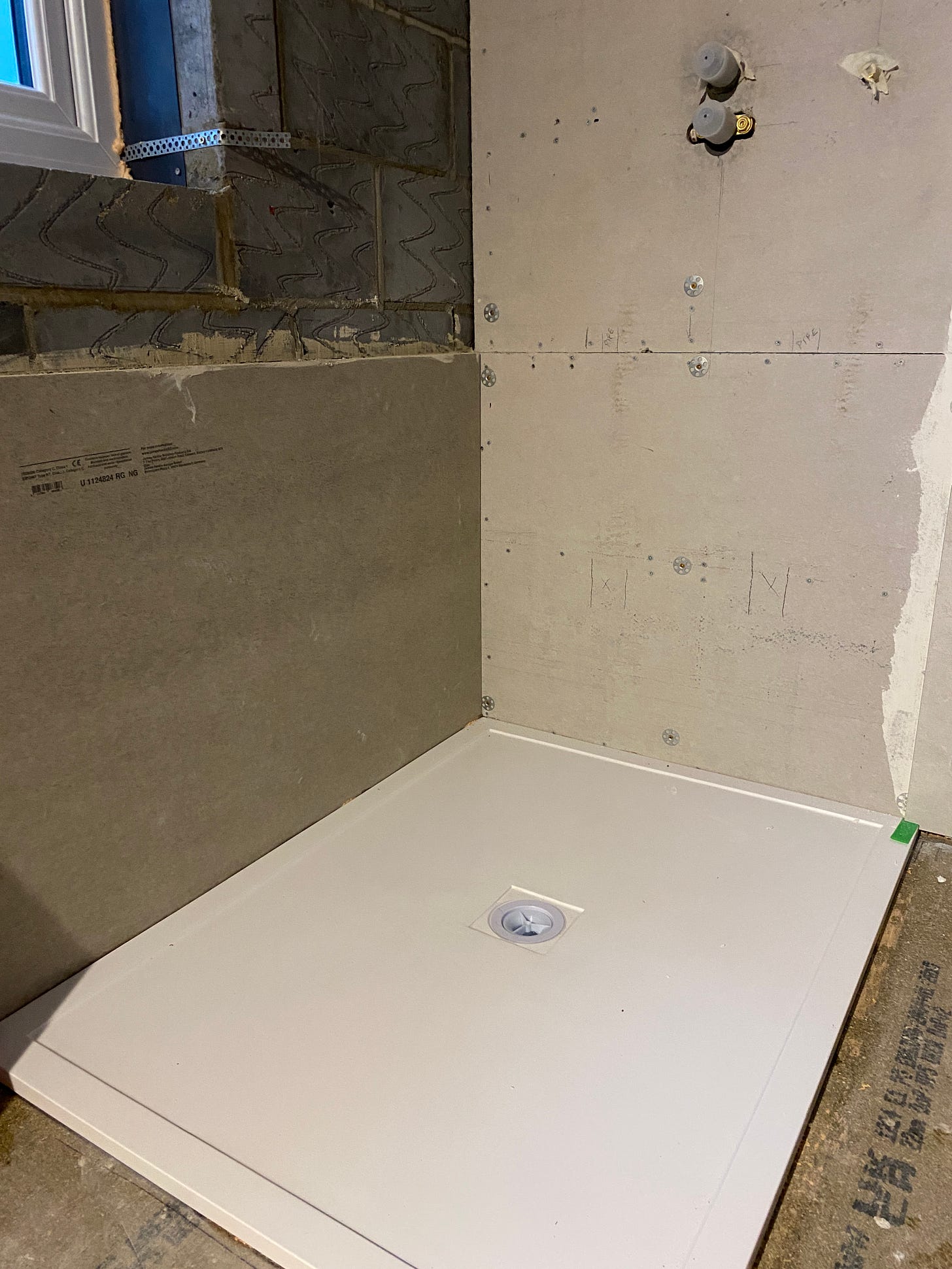 white stone shower tray positioned on the floor