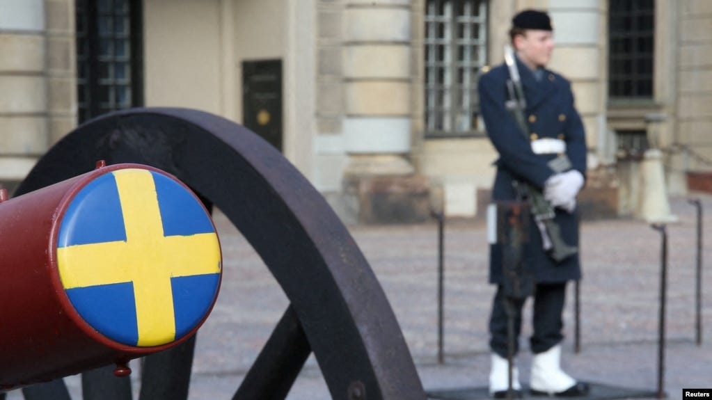 A Swedish soldier stands guard next to a ceremonial cannon in the courtyard of the Royal Palace in Stockholm on February 25.