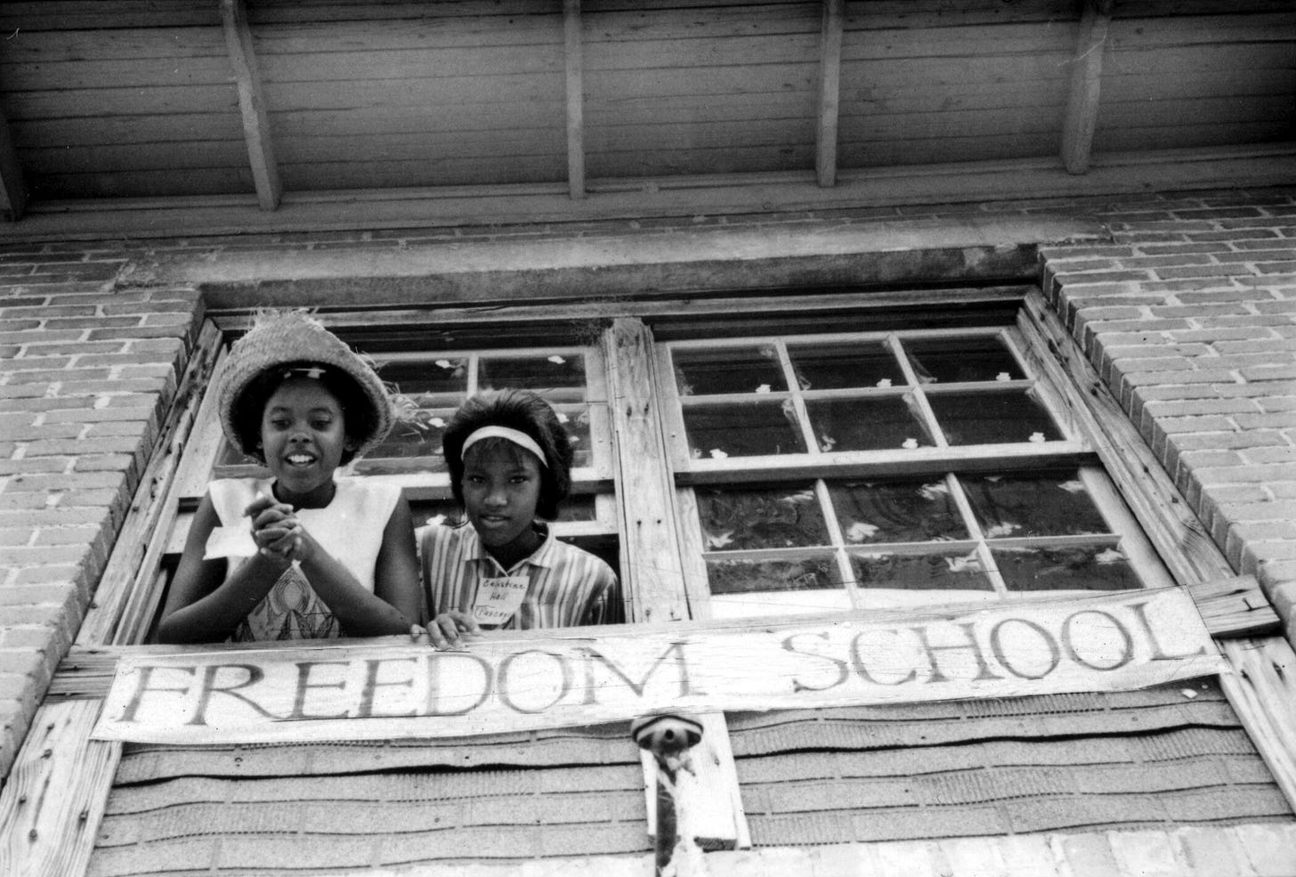 Two girls look out the window of a “Freedom School.”