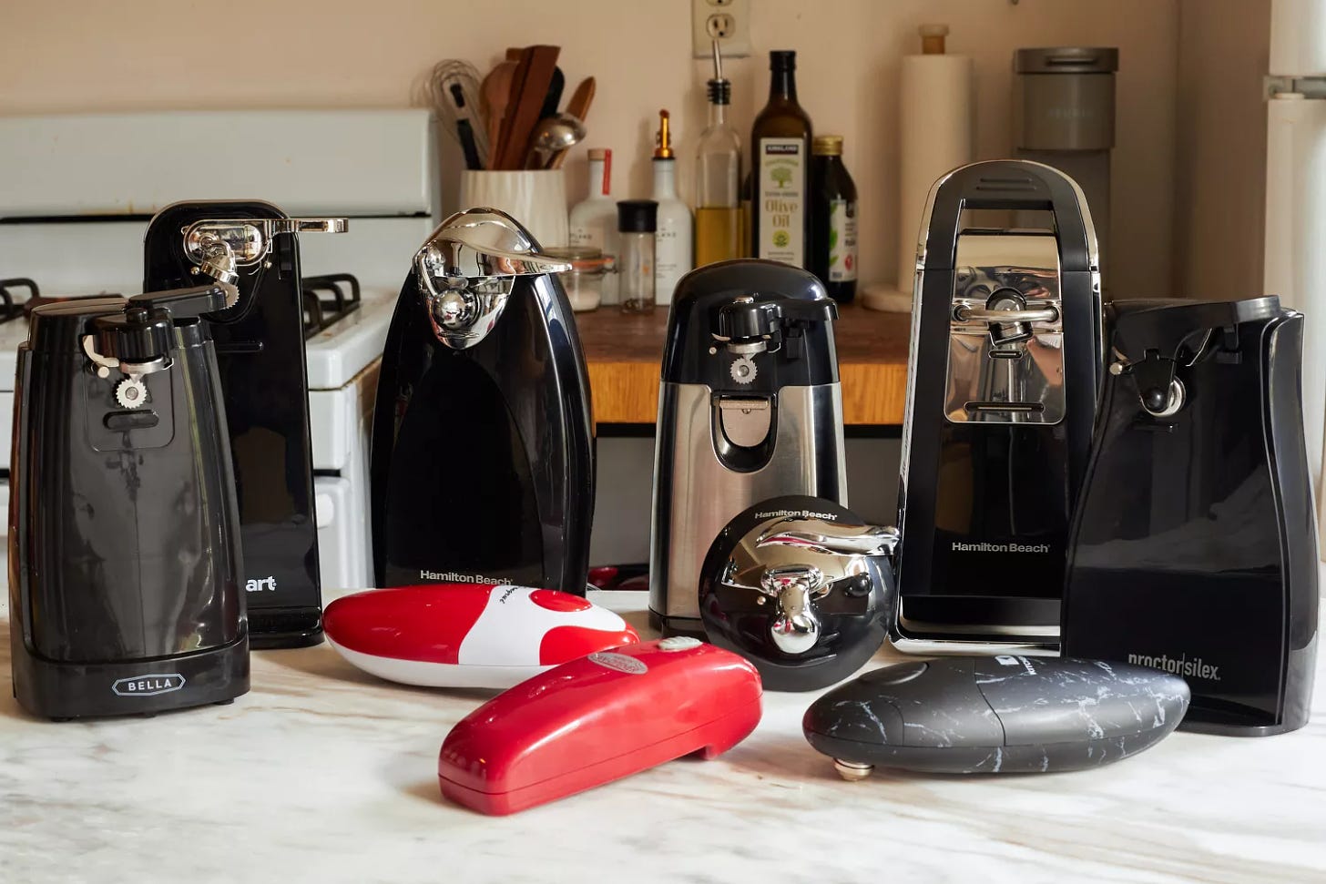 A group of electric can openers on a kitchen countertop