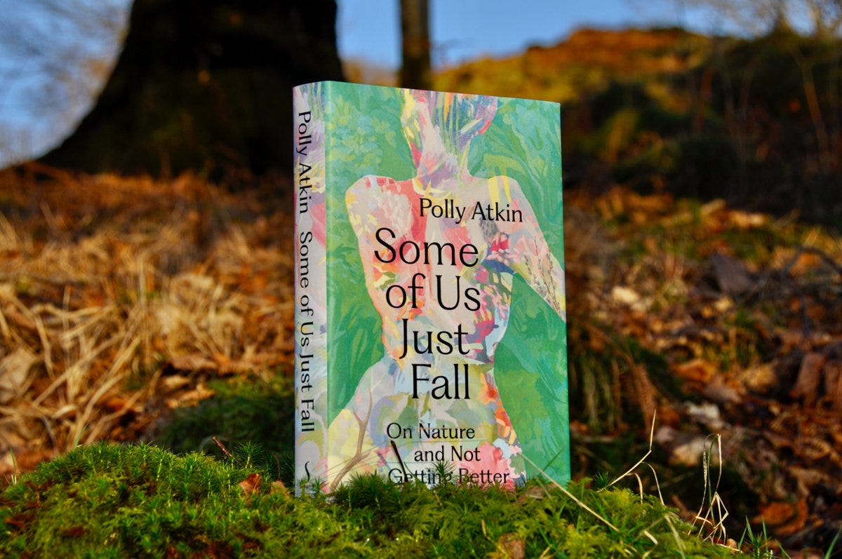A hardback copy of Some of Us Just Fall by Polly Atkin resting on a background of fall leaves with a blue sky