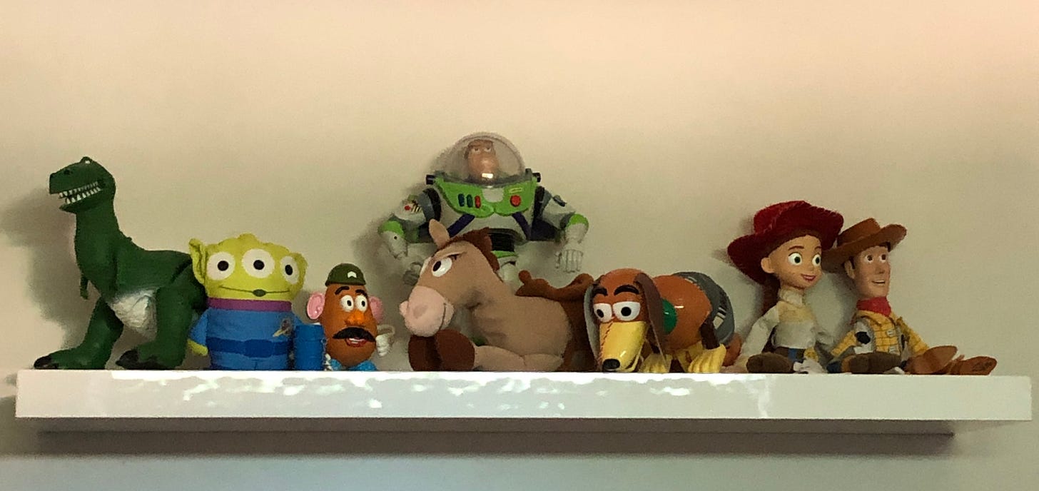 Toy Story figures hanging out on a white floating shelf.