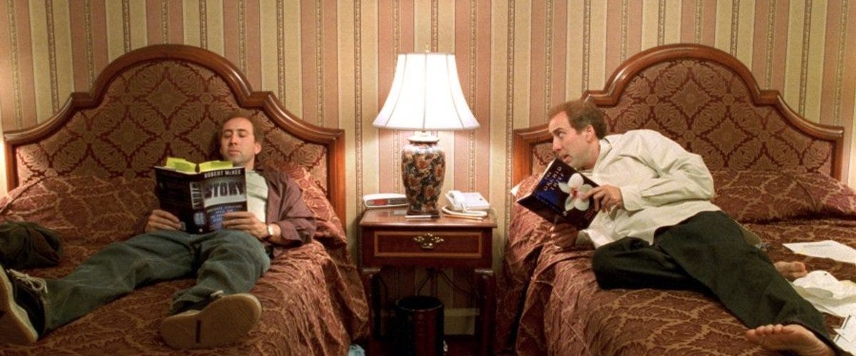 Still from Adaptation. Charlie and Donald Kaufman lie in separate hotel beds reading books.