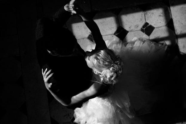 Black and white photo of a couple waltzing. Image is taken from above looking down at the couple.
