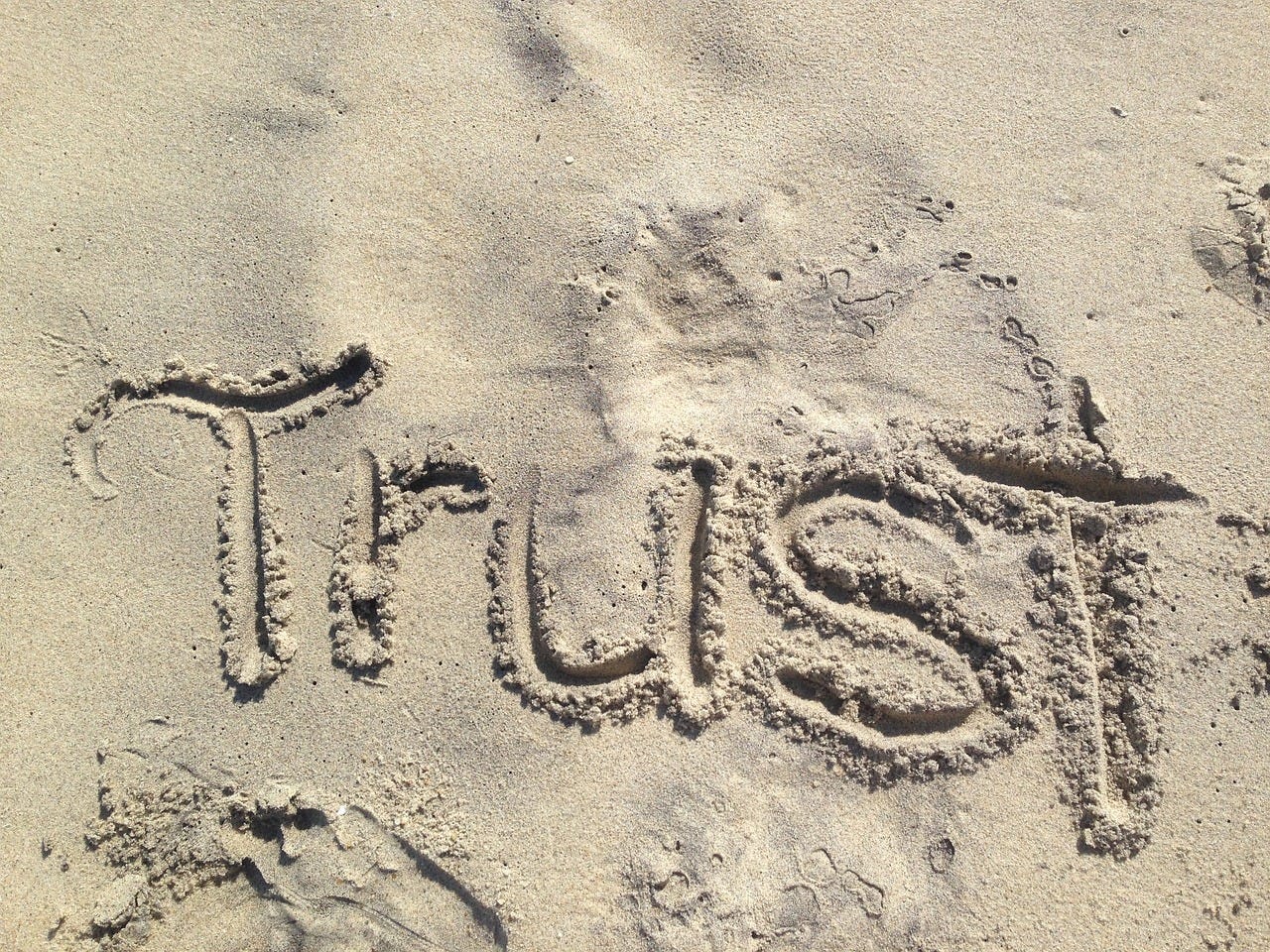 The word trust written in the sand meaning trust the process The word trust written in the sand meaning trust the process