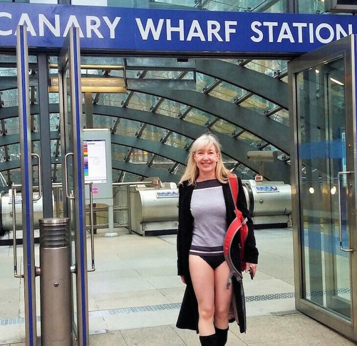 No Trousers Tube Ride London: a woman standing outside Canary Wharf tube station without any trousers on