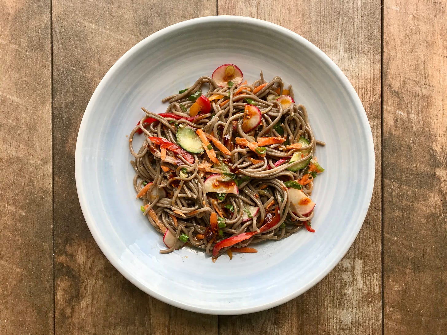 Thin slices of cucumber and radish with slivers of red and orange sweet peppers, carrot shreds and sliced spring onions are tangled in tresses of buckwheat noodles. It’s sprinkled with coriander leaf, sesame seeds and dotted with chilli crisp.