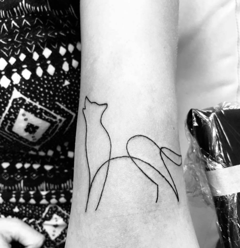 A minimalist, single-line Siberian husky or wolf tattoo