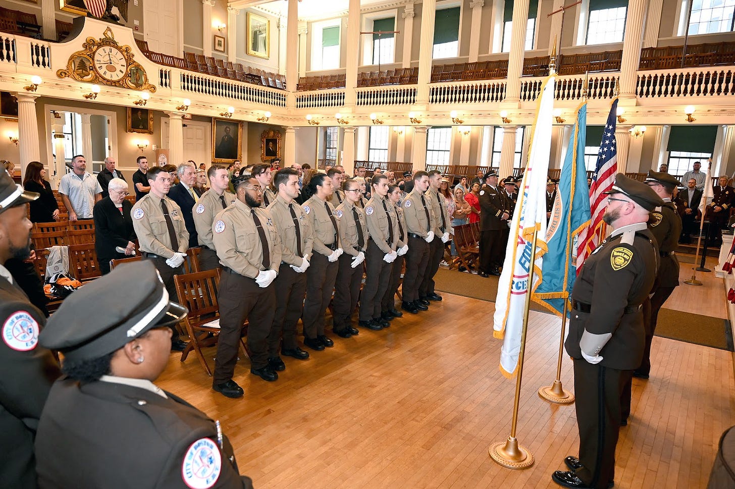 The incoming recruits stand at attention before the graduation ceremony begins in Faneuil Hall