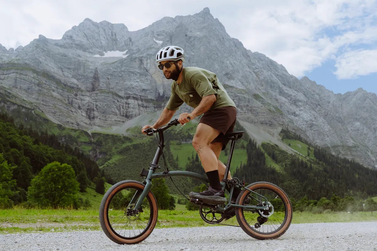 Man riding Brompton G Line with mountains in background.