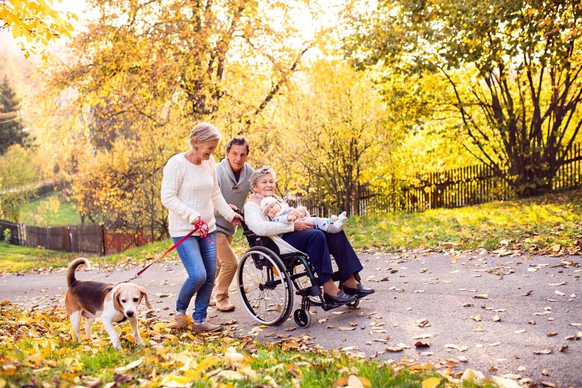 Extended family with dog on a walk in autumn nature.