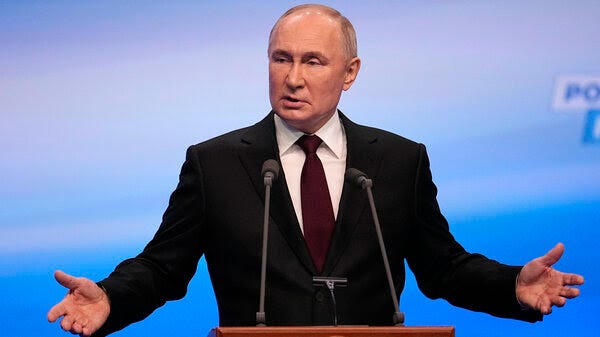 Russian President Vladimir Putin gestures while speaking on a visit to his campaign headquarters after a presidential election in Moscow, Russia, early Monday.
