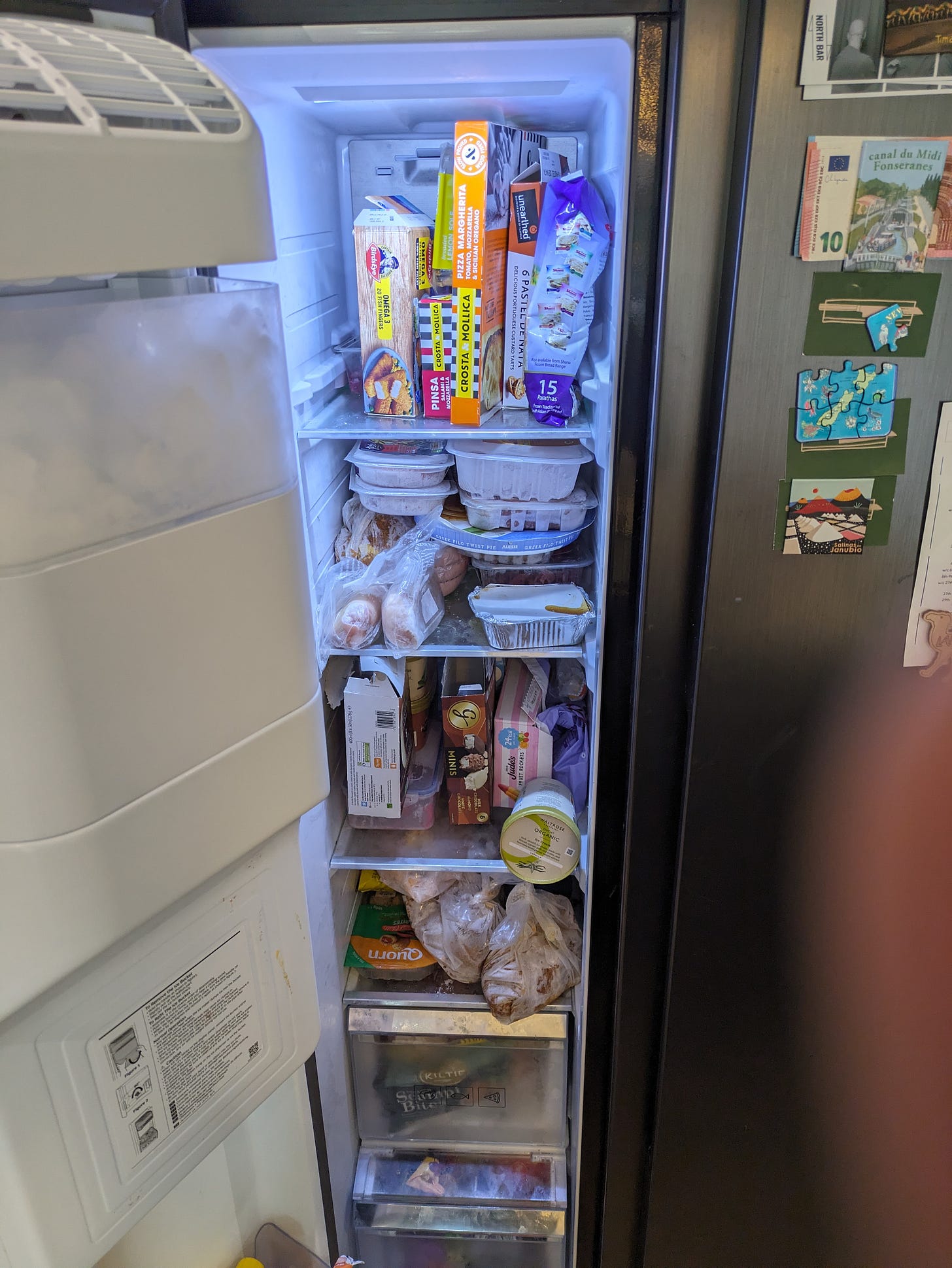 An american style freezer is full off food that may not get eaten