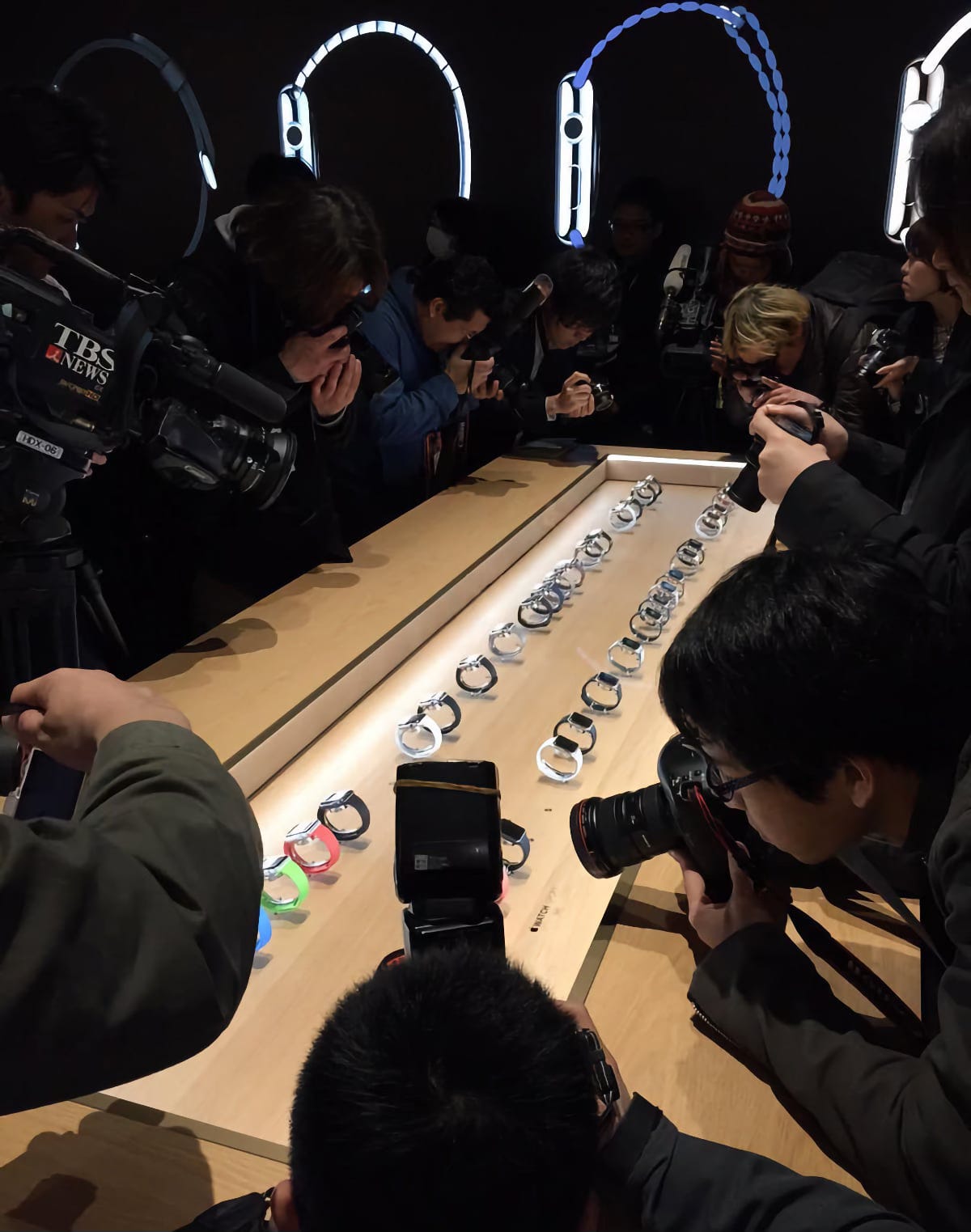 Photographers and reporters crowd around the Apple Watch display table at Isetan Shinjuku.