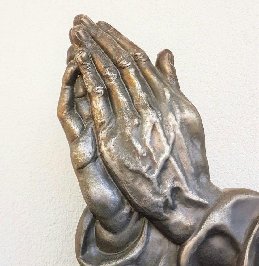 gray praying hand statue