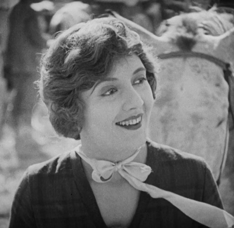 Lois Wilson as Milly Wingate in 1923 film The Covered Wagon. She smiles in a medium shot