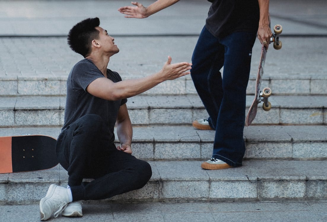 Free Content Asian male friends clapping each other hands on street Stock Photo