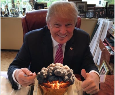 Donald Trump eating from a bowl containing a nuclear explosion