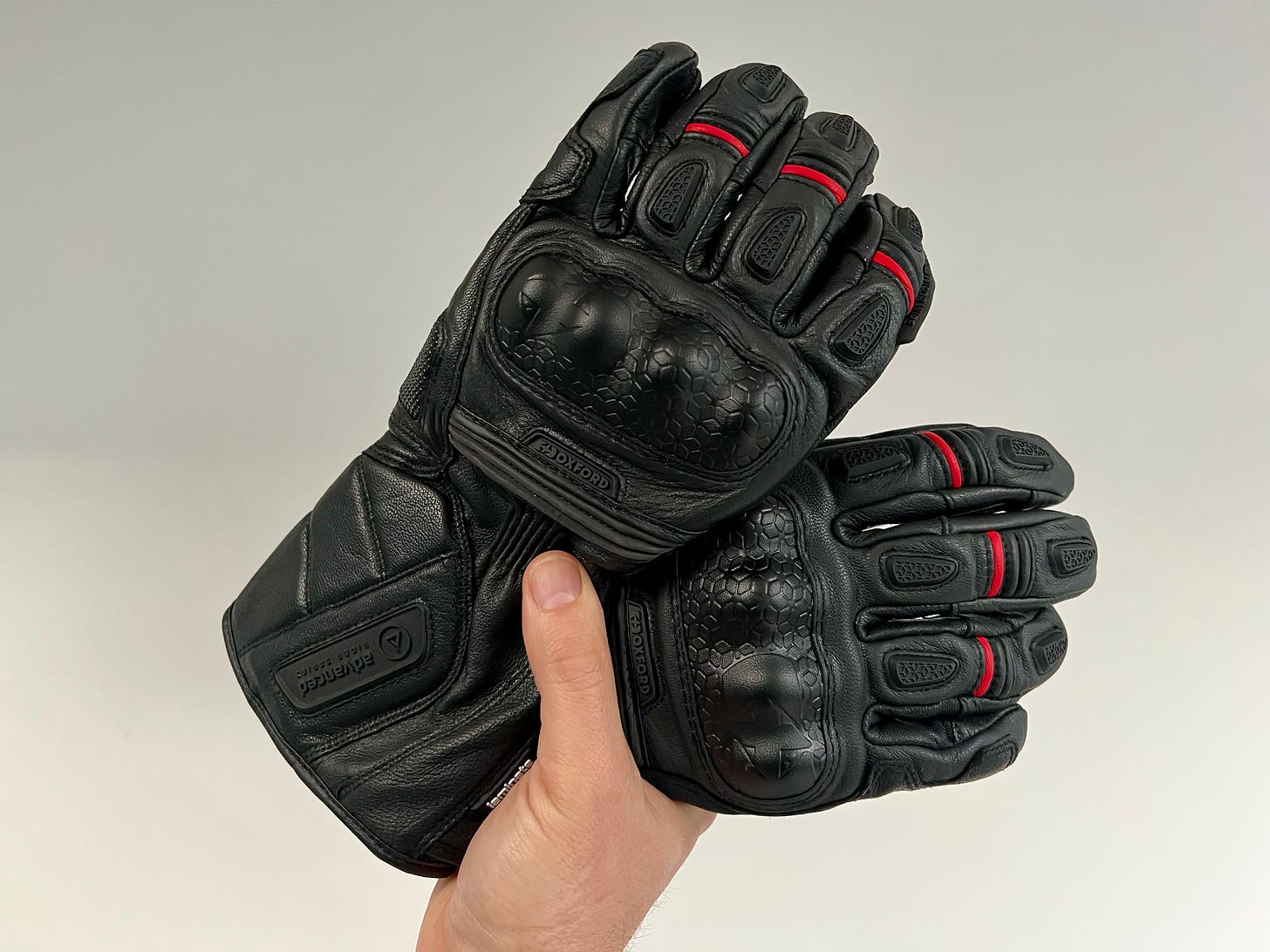 A hand holds two leather gloves. I guess that could also be called a pair.