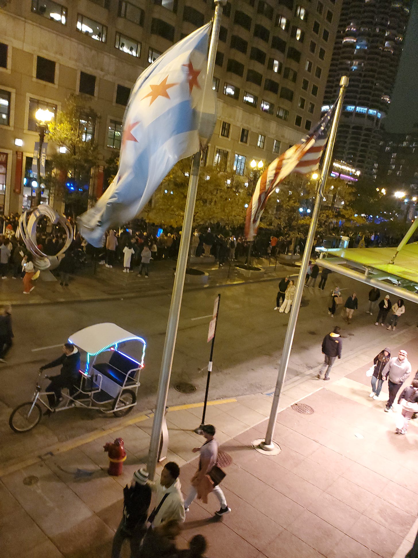 Waving Chicago and American flags, a cycle taxi, and parade-goers