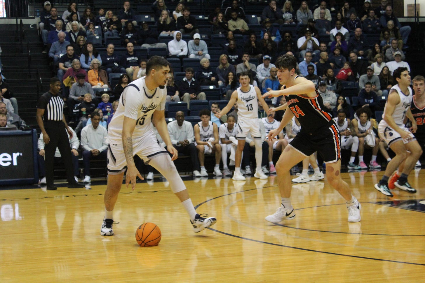 Monmouth’s Amaan Sandhu dribbles at the top of the key with Princeton’s Zach Martini defending on Nov. 18, 2023. (Photo by Adam Zielonka)