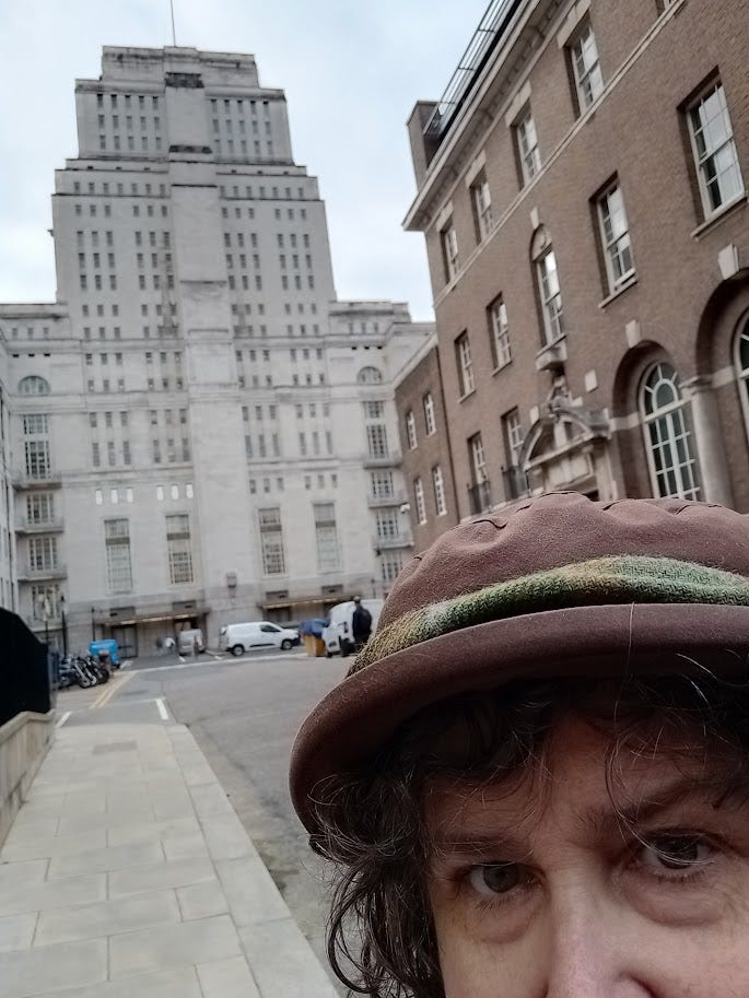 Very tall 1930s white building, not quite a skyscraper, with Annette looking alarmed