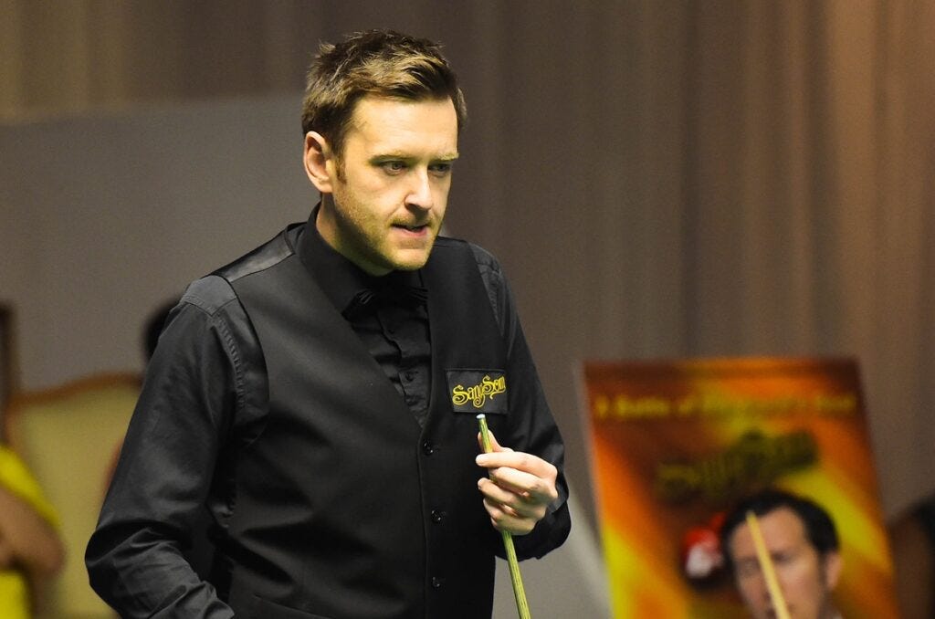 Snooker player Ricky Walden focused during a match, holding his cue in a professional tournament setting