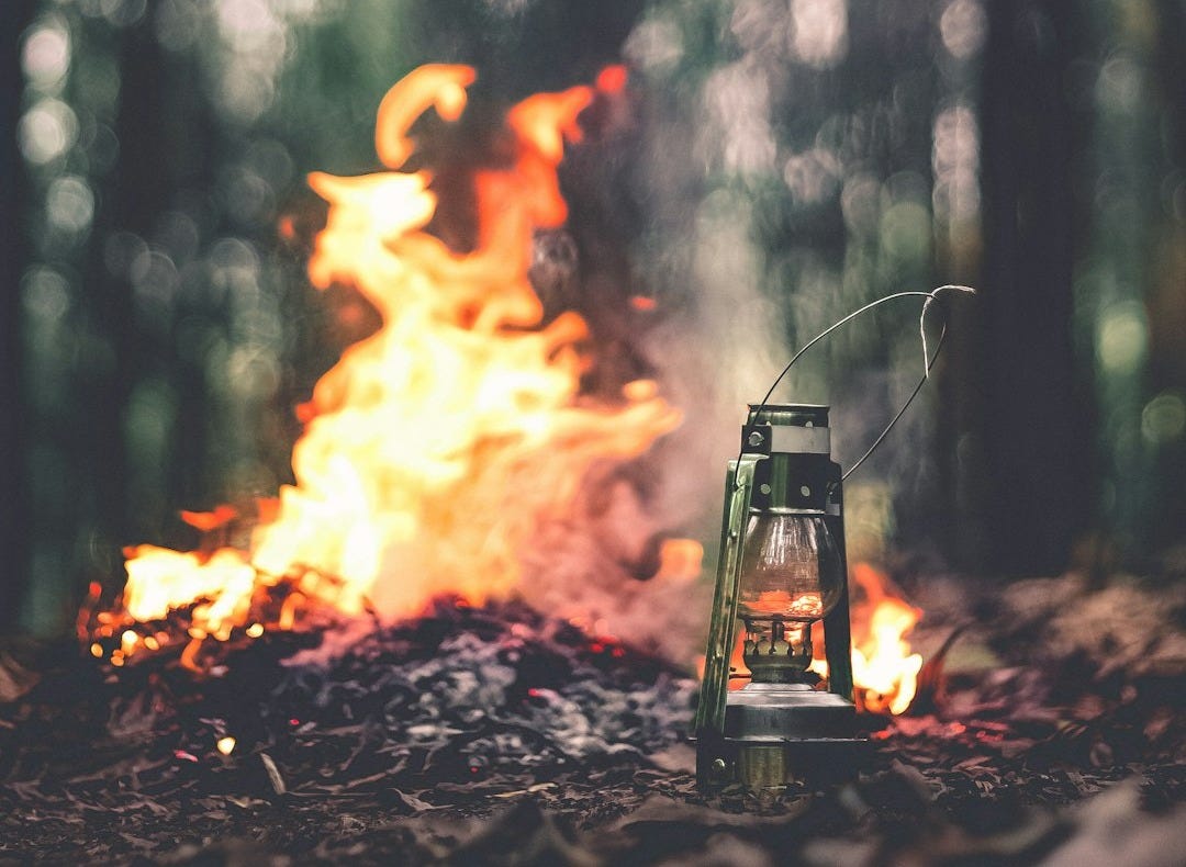 green lantern beside the bonfire on brown grass green lantern beside the bonfire on brown grass