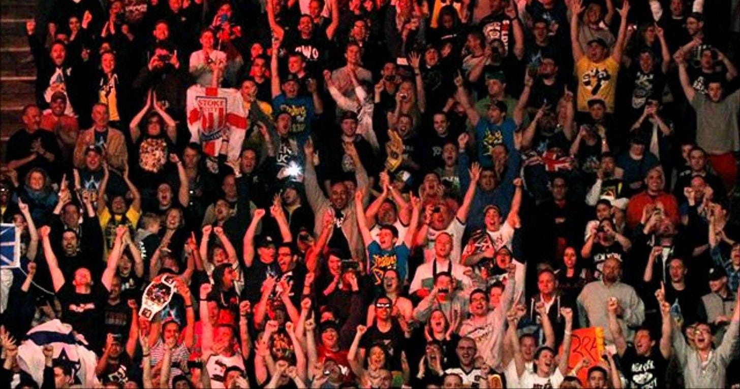 A large crowd of people with their hands up

Description automatically generated