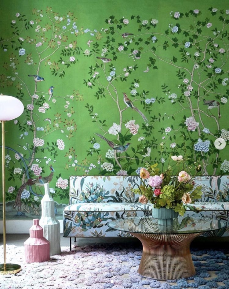 Emerald green Chinoiserie wallpaper by de Gournay with floral sofa, textured rug and glass coffee table.