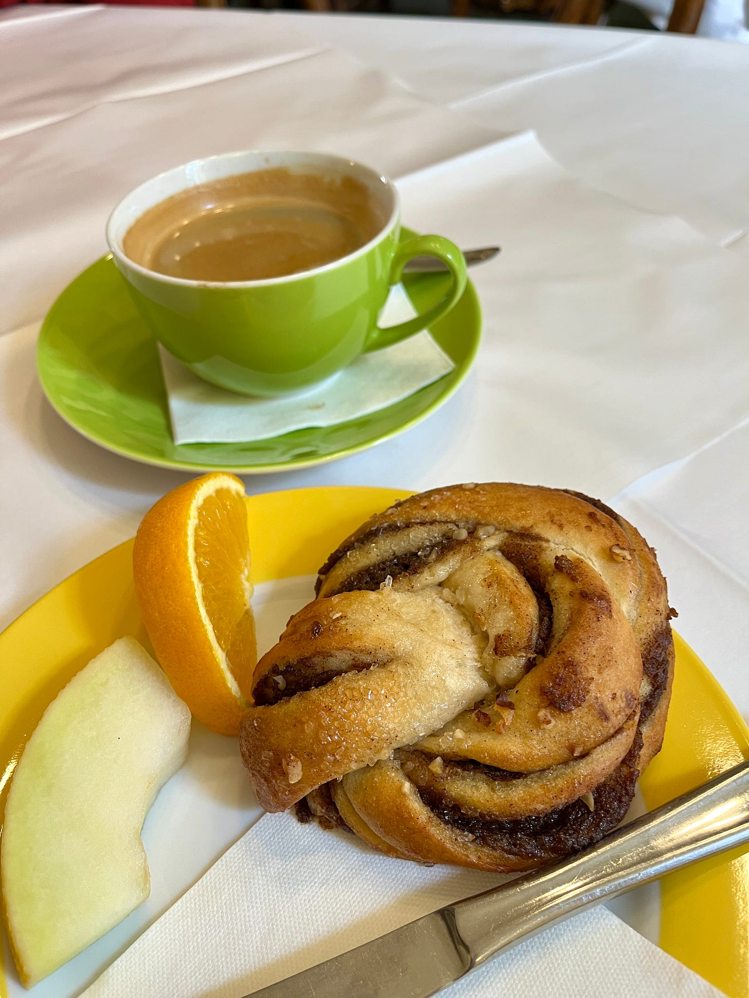 swirled cinnamon pastry with a cup of coffee