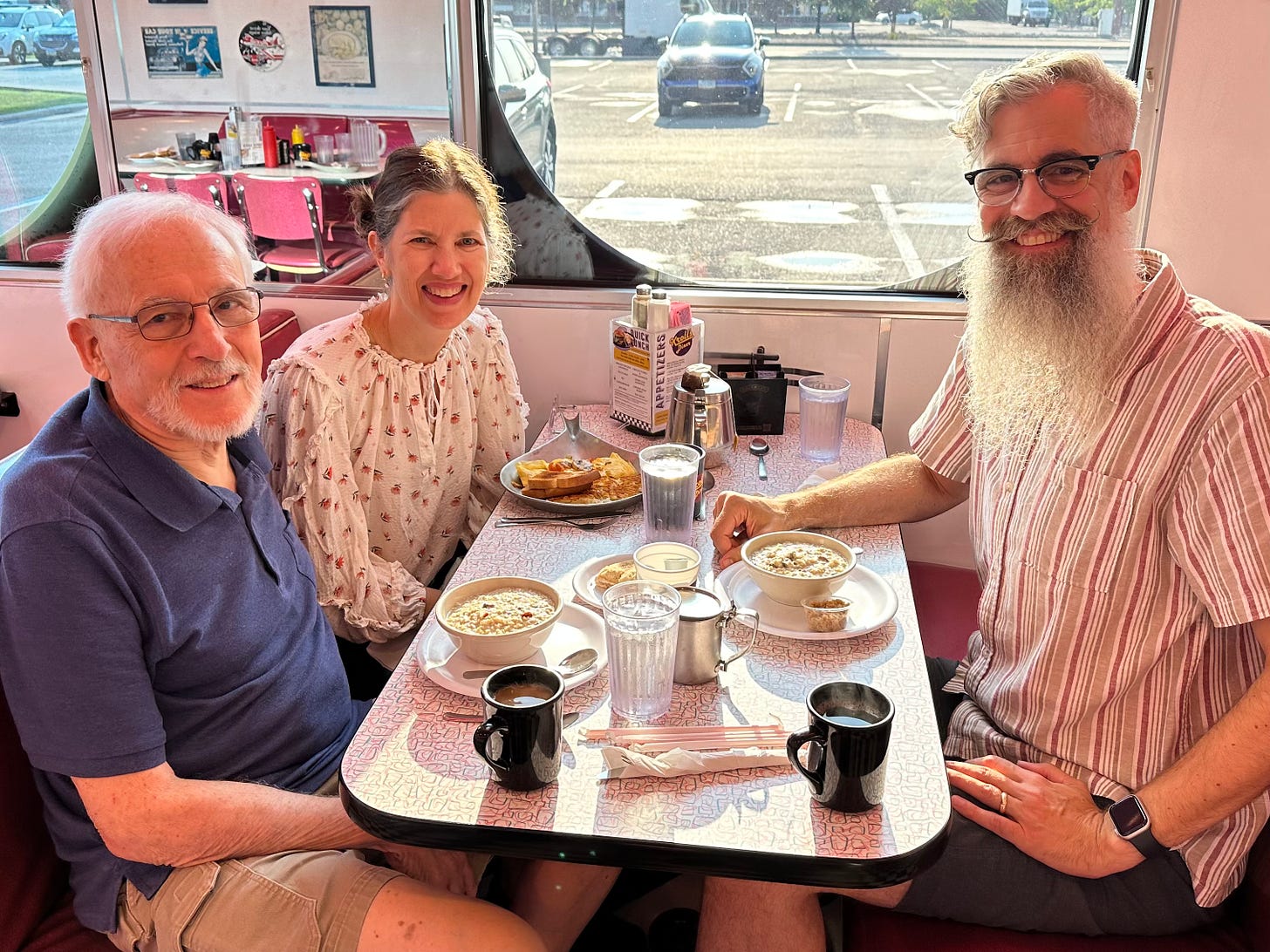 An 80-something man with his two middle-aged children sitting in a diner enjoying bowls of oatmeal and an egg skillet ...