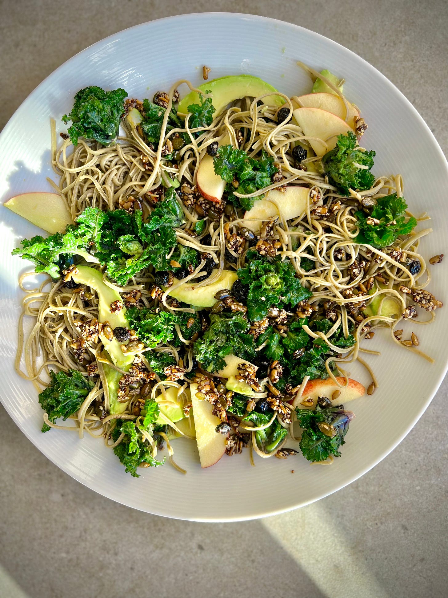 bowl of kalette noodle salad with savoury seed granola