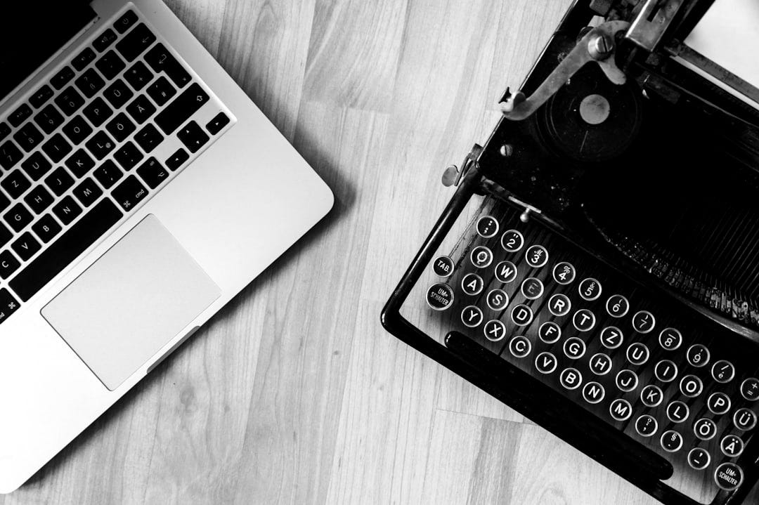 MacBook beside typewriter machine MacBook beside typewriter machine