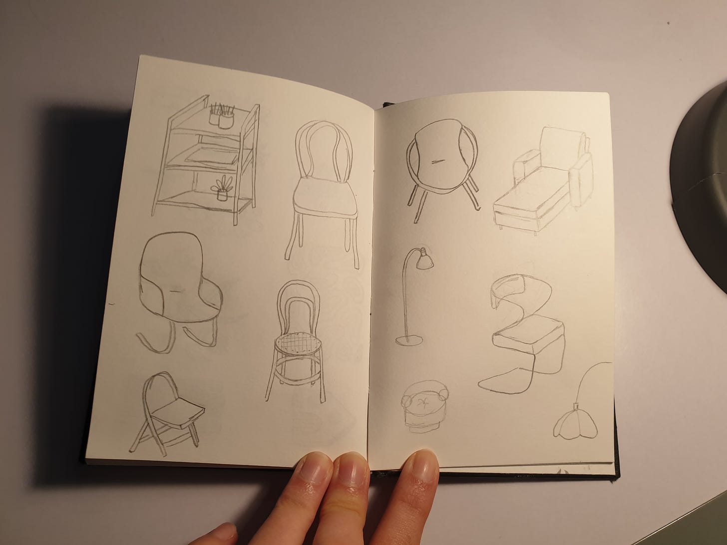 sketches of chairs and lamps on a notebook