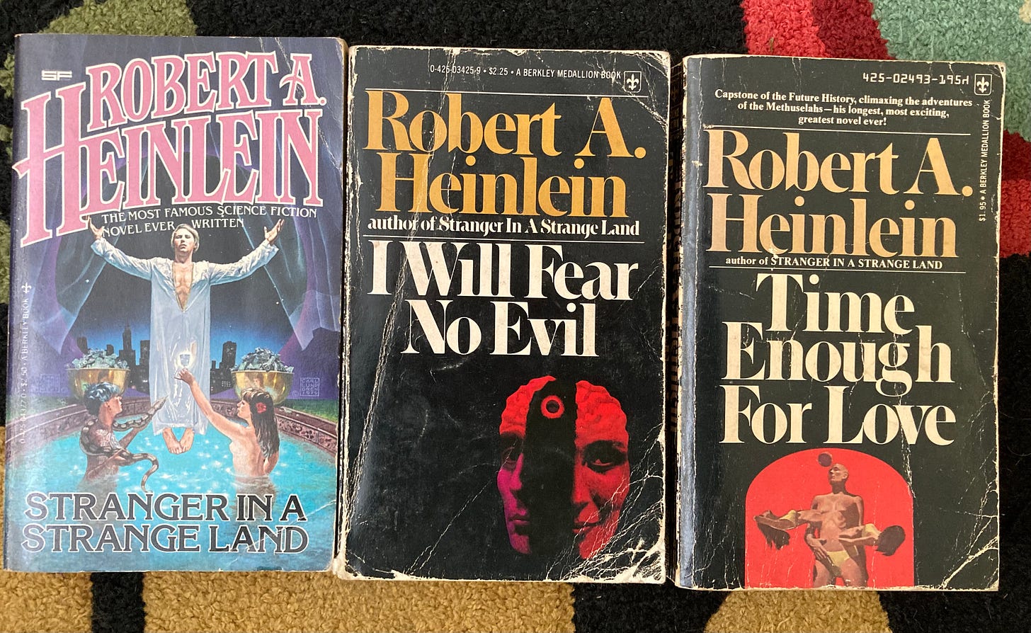 Paperback Book covers of three Robert Heinlein novels: Stranger in a Strange Land, I Will Fear no Evil, and Time Enough For Love