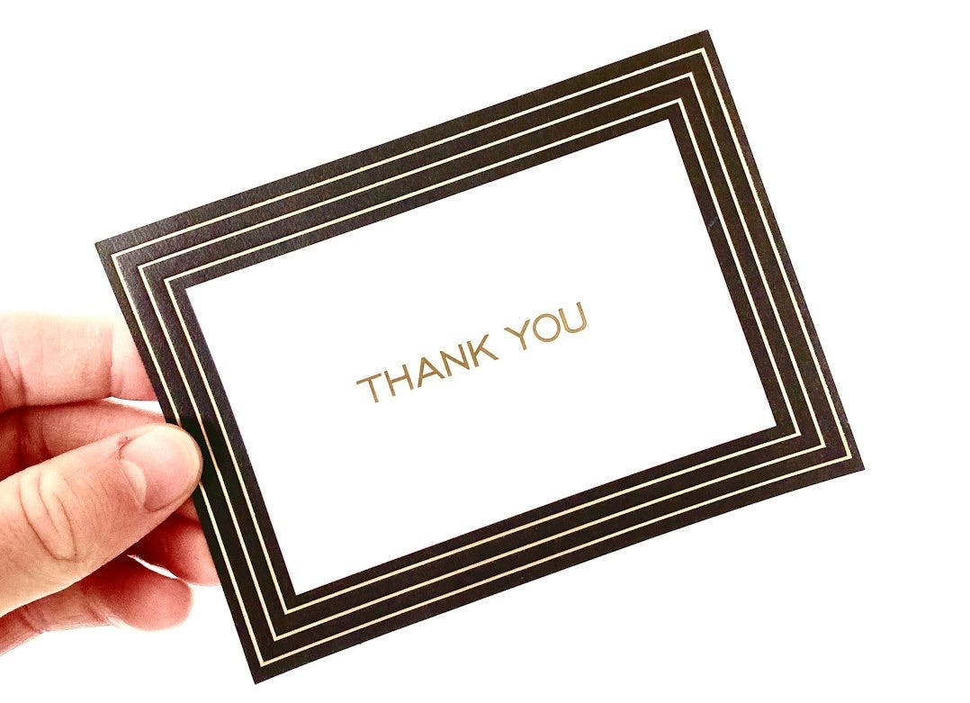 A hand holding a thank card with the words thank you A hand holding a thank card with the words thank you