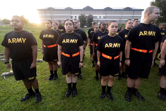 FILE - Students in the new Army prep course stand at attention after physical training exercises at Fort Jackson in Columbia, S.C., Aug. 27, 2022. The Army is trying to recover from its worst recruiting year in decades, and officials say those recruiting woes are based on traditional hurdles. The Army is offering new programs, advertising and enticements to try to change those views and reverse the decline. (AP Photo/Sean Rayford, File)