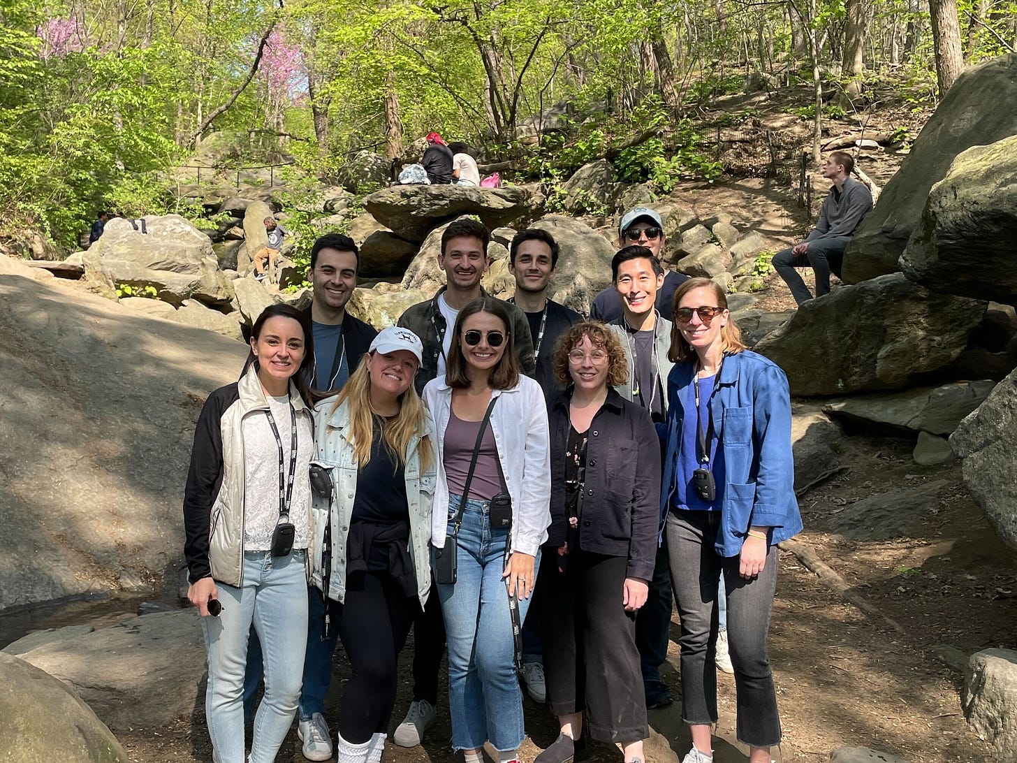 A group of people are surrounded by rocks and trees and appear to be happy