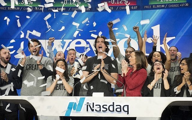 In this Jan. 16, 2018 file photo, Adam Neumann, center, co-founder and CEO of WeWork, attends the opening bell ceremony at Nasdaq in New York (AP Photo/Mark Lennihan)