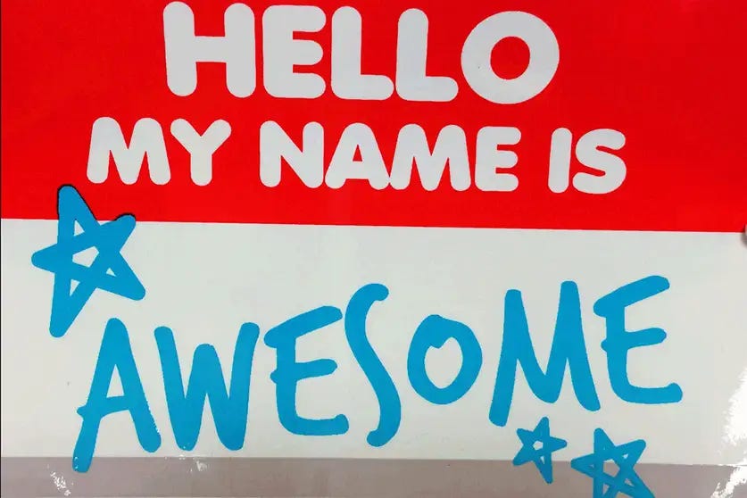 Red and white nametag states, “Hello my name is awesome,” with three blue stars.